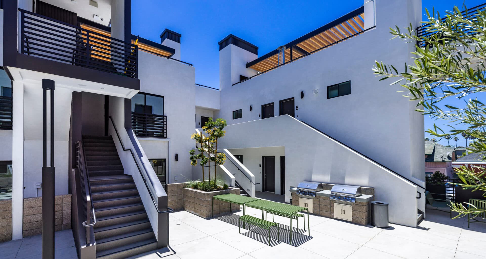 Courtyard with staircases and picnic tables at The Kalthom, a Class A multifamily property in Ventura