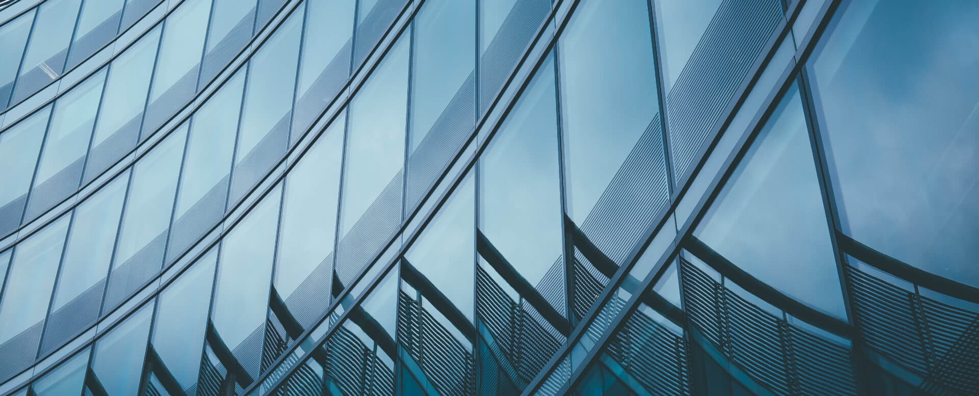 Modern glass office tower facade representing Matthews H1 2026 commercial real estate growth and technology expansion