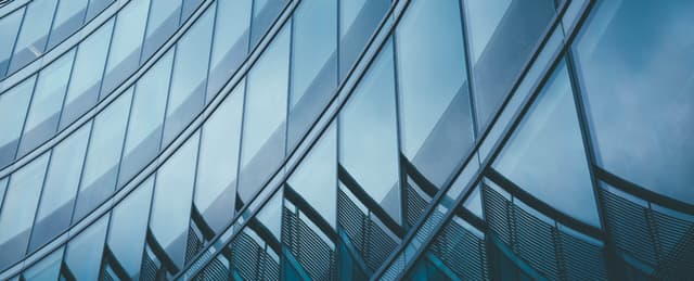 Modern glass office tower facade representing Matthews H1 2026 commercial real estate growth and technology expansion