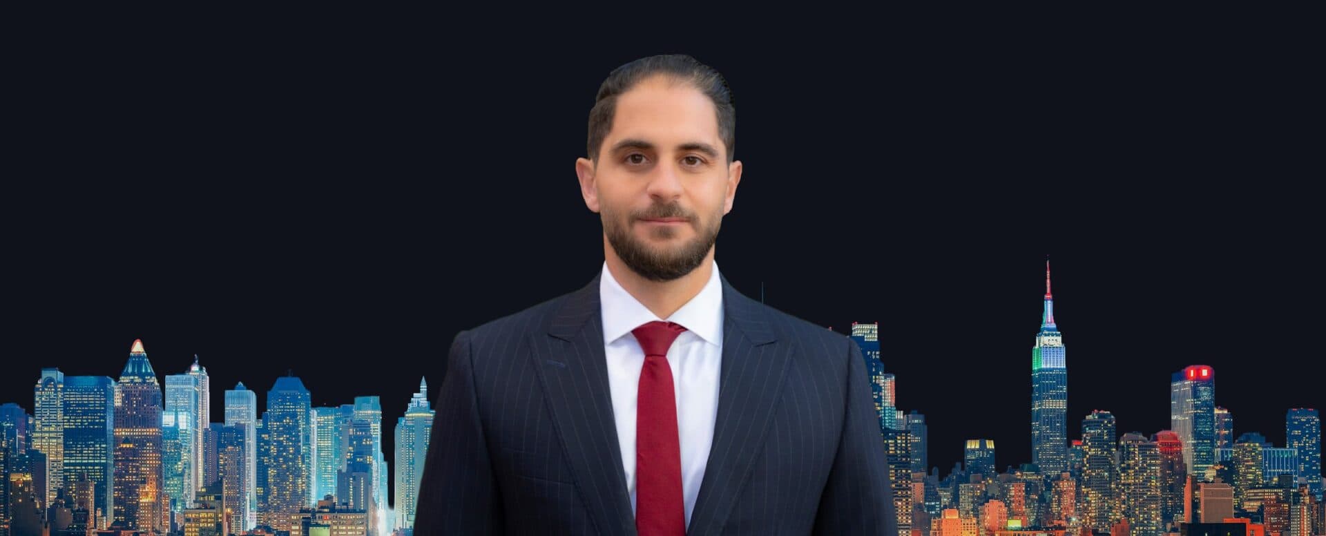Isaac Shabot, a New York City brokerage veteran, in a dark suit and red tie in front of the New York skyline at night